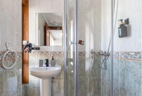 a bathroom with a sink and a shower at EMAROOMS Laredo in Laredo