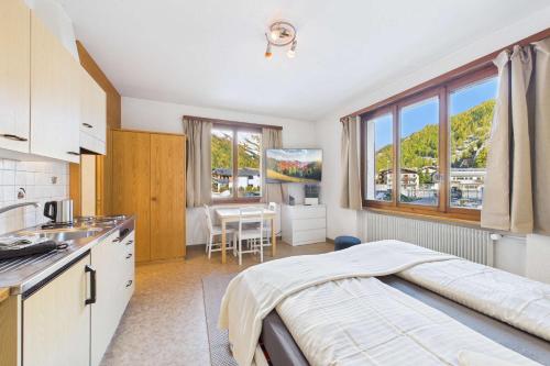 Studio in Saas-Grund quiet and centrally located في ساس-غروند: مطبخ فيه سرير وطاولة