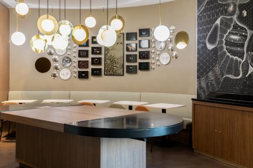 パリにあるノボテル スイーツ パリ エキスポ ポルト ド ベルサイユのダイニングルーム(テーブル、ペンダントライト付)