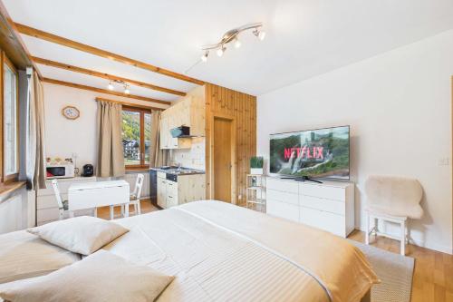 a bedroom with a large bed and a kitchen at Comfortable studio with balcony and panoramic view in Saas-Grund