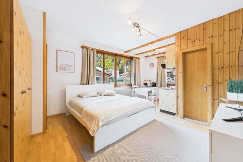 a bedroom with a bed and a kitchen at Comfortable studio with balcony and panoramic view in Saas-Grund