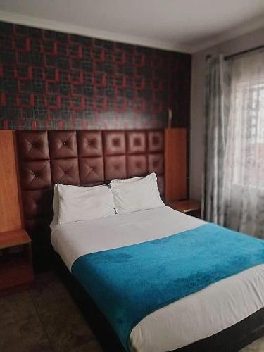 a bedroom with a large bed with a blue blanket at Lookout Star Legend Accommodation in Parow
