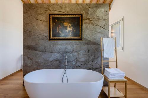 a bath tub in a bathroom with a painting on the wall at Villa Il Morino in Centofinestre