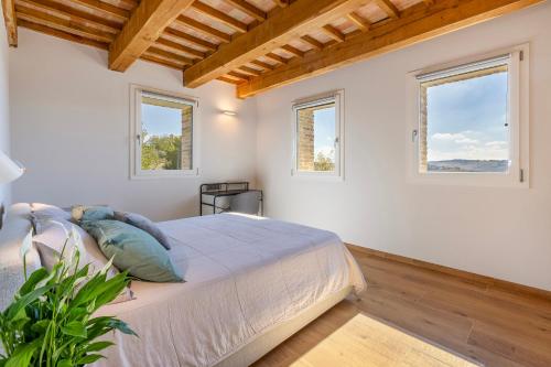a bedroom with a bed and two windows at Villa Il Morino in Centofinestre