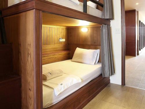 a bed in a wooden frame in a room at Hogwortz Hostel & Tour in Krabi
