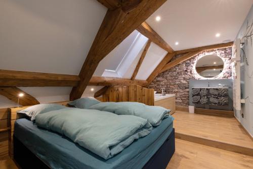 a bedroom with a large bed in a attic at Lorenz Home - Gîte d exception & balnéo in Neuve-Église