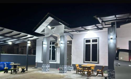 a house with a table and chairs in front of it at Wan Z Homestay Pasir Mas in Pasir Mas