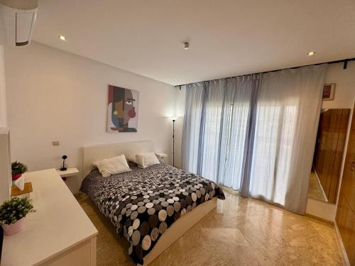 达布阿扎Peninsula Dar Bouazza Superbe appartement en résidence avec piscine activités的一间带床和大窗户的卧室