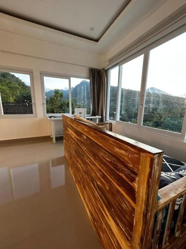 a room with large windows and a wooden bench at Waenis Sunset View Hotel and Restaurant, Amed, Bali in Amed