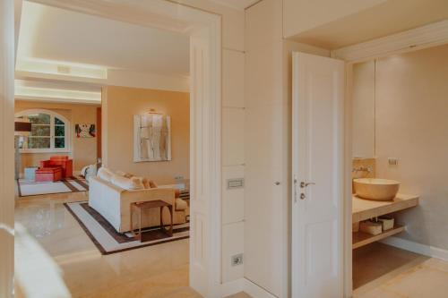 a bathroom with a sink and a room with a couch at Villa Aria in San Felice del Benaco