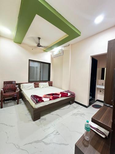 a bedroom with a large bed and a green ceiling at Hotel Krishna Raj in Ujjain