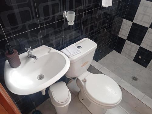 a bathroom with a white toilet and a sink at Casa en Atuntaqui in Atuntaqui