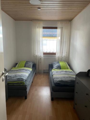 two beds in a small room with a window at Ferienwohnung Susanne in Burglengenfeld