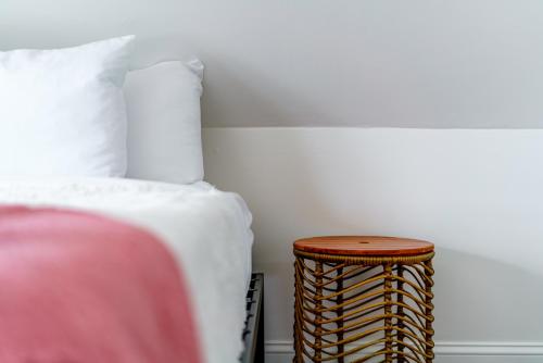 une chambre avec un lit et une table de chevet en rotin dans l'établissement Prime Location Top Rated Clean Parking Free!, à Columbus