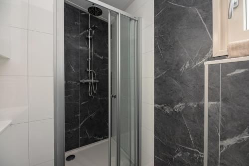 una ducha con puerta de cristal en un baño en Veluwepark de Bosgraaf, en Apeldoorn