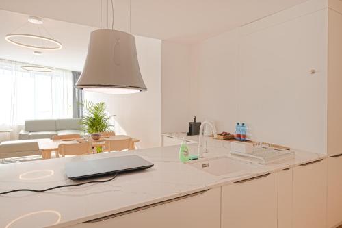 a white kitchen with a laptop on a counter at Skau Sky Park Mint by Zaha Hadid 22 Floor 1 Tower Free Parking in Staré Mesto