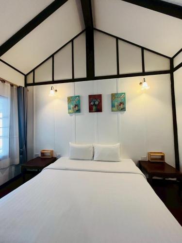 a bedroom with a large white bed with two pillows at River View House in Ko Chang