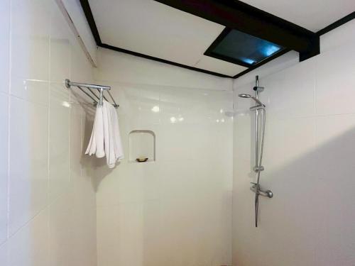 a shower stall in a bathroom with a white wall at River View House in Ko Chang