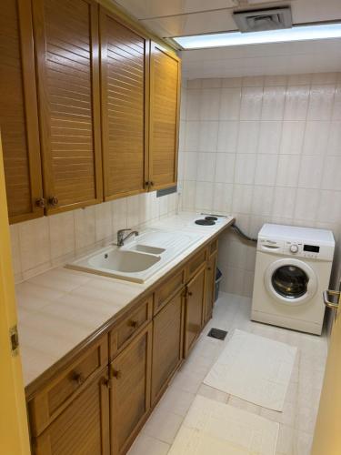 a kitchen with a sink and a washing machine at Top Hotel Apartments in Al Ain