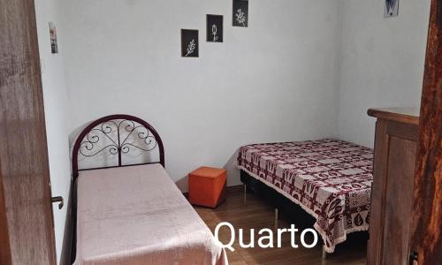 a small bedroom with a bed and a small table at Aconchego Brasileirinho Para-ti in Paraty