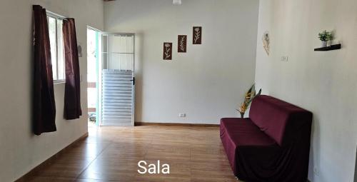 a living room with a purple couch in a room at Aconchego Brasileirinho Para-ti in Paraty