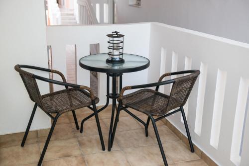 a glass table and two chairs in a room at Eden Beach Hotel in Agia Marina Nea Kydonias