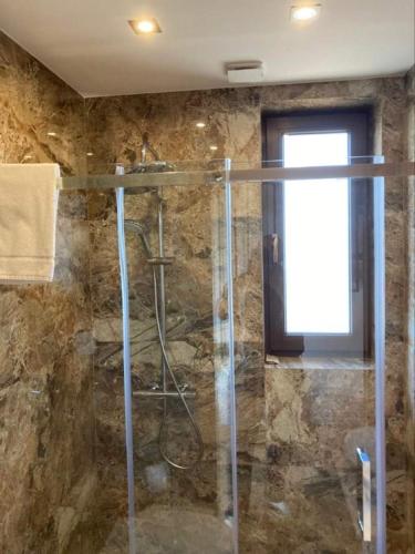 a bathroom with a shower with a glass door at Domki u Krużla in Bańska Wyżna