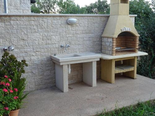 a stone sink and a brick oven in a patio at Apartments Orange Medulin in Medulin