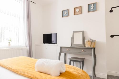 a bedroom with a bed and a desk with a mirror at Northumberland Cosy Home in Bedlington