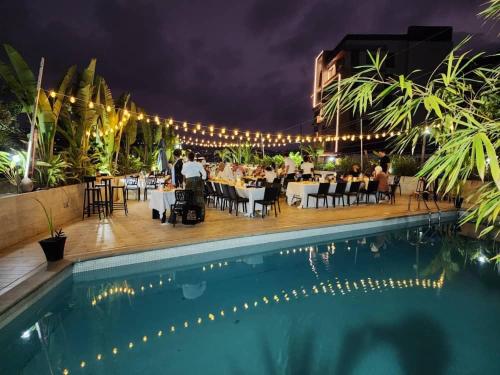 a restaurant next to a swimming pool at night at The Swiss Hotel Freetown in Freetown