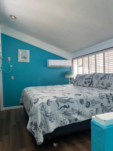 a blue bedroom with a bed and a blue wall at Sky Blue 321 in Cedar Key