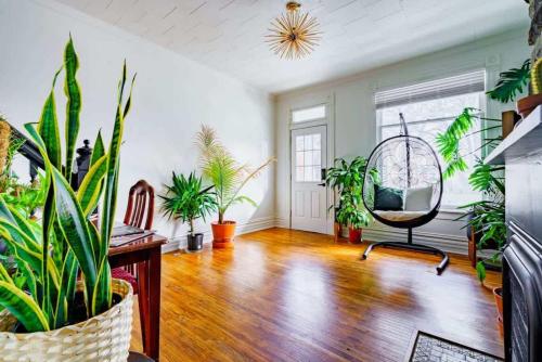 a living room with a chair and plants in it at Short North Convention King Bed Free Parking! in Columbus