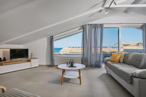 a living room with a couch and a table at Sofita Sea View Apartment, By TK Property Management in Argasi