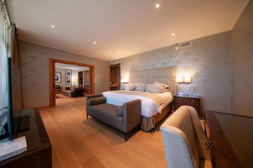 a bedroom with a bed and a couch and a television at Hotel Parada Linares in Linares