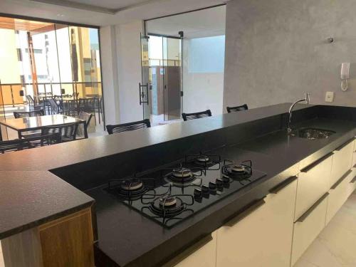 una cucina con piano cottura e piano cottura di lavoro nero. di Flat encantador na praia de Intermares com piscina a Ilha da Restinga