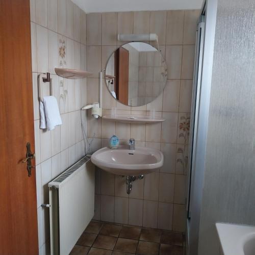 a small bathroom with a sink and a mirror at Landhaus im kühlen Grunde Garni in Pracht