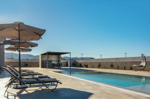 - une rangée de chaises longues avec un parasol et une piscine dans l'établissement Samantha Villa, By TK Property Management, à Kalpaki