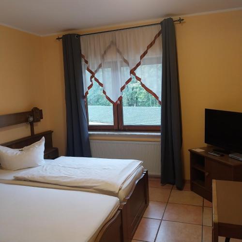 a bedroom with two beds and a window at Landhaus im kühlen Grunde Garni in Pracht