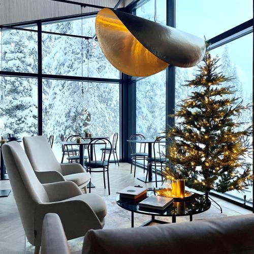 un soggiorno con un albero di Natale e una grande finestra di Magical Pond Nature Igloos a Ruka
