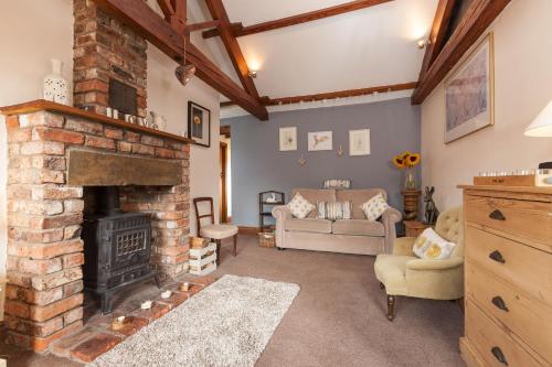 a living room with a fireplace and a couch at Skipbridge Farm Cottages in Green Hammerton