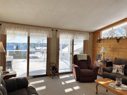 a living room with a couch and chairs and a balcony at Hazel House in Saint Ignace
