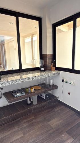 a kitchen with two large windows and a counter at Suite La Lomita #3 Climatizada in Tuxtla Gutiérrez