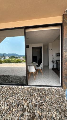 a glass window of a house with a table and chairs at Suite La Lomita #3 Climatizada in Tuxtla Gutiérrez