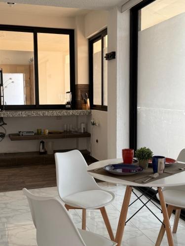 a dining room with a table and white chairs at Suite La Lomita #3 Climatizada in Tuxtla Gutiérrez