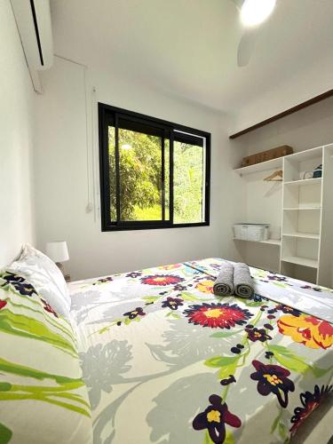 a bedroom with a bed with a floral bedspread at Le nid d'Emijulie - Maison familiale proche plage in Gourbeyre