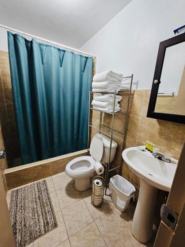 a bathroom with a toilet and a sink and a shower at Joe's Place 1 bedrm, 1 bathrm in Sinajana