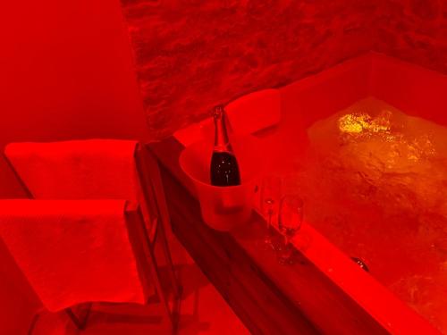 a red room with a table with a bottle and glasses at Ecrin des sens in Levens