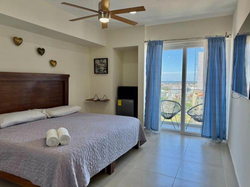 a bedroom with a bed and a ceiling fan at Habitacion Frente al Malecon By Partner Host in Mazatlán