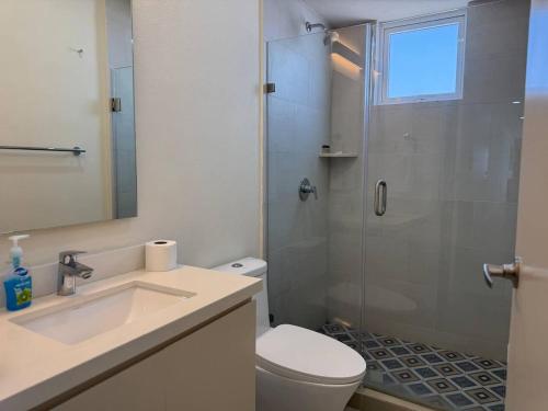 a bathroom with a shower and a toilet and a sink at Habitacion Frente al Malecon By Partner Host in Mazatlán