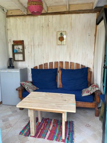 een bank met blauwe kussens en een tafel in een kamer bij Lugar bonito tiny house in Lago Puelo
